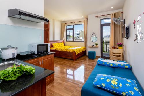 a living room with a blue couch and a yellow bed at Loving Homestay & Apartment Da Nang in Da Nang
