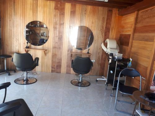 a salon with three mirrors and chairs in a room at Hostal Villa Brisa in Ballenita
