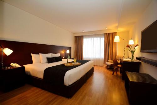 um quarto de hotel com uma cama grande e uma secretária em Dazzler by Wyndham Lima Miraflores em Lima
