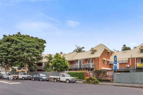 uma fila de carros estacionados em frente a um edifício em Spring Hill Terraces em Brisbane