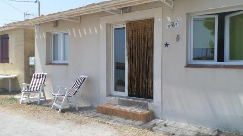 twee stoelen op de veranda van een huis bij Cabanès des Aresquiers avec jacuzzi in Frontignan