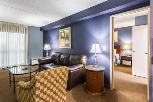 Una sala de estar con un sofá de cuero y una mesa. en Plaza Inn & Suites, en Hagerstown