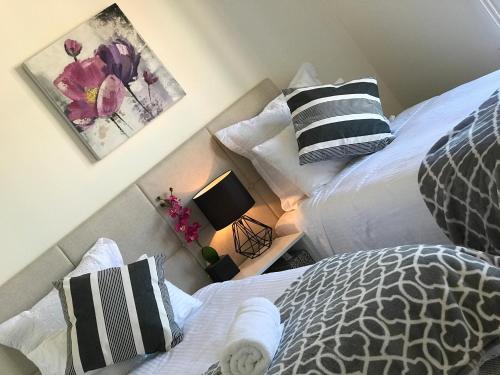 1 dormitorio con 2 camas y mesa con lámpara en Melbourne Inner City Holiday Home Near CBD & Flemington en Melbourne