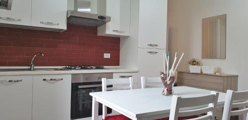 una cucina con tavolo bianco e sedie bianche di La Casa di Alberto a Bolsena