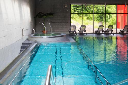una gran piscina con sillas en un edificio en Hotel Ländli, en Oberägeri