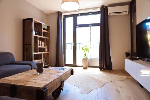 een woonkamer met een salontafel en een groot raam bij AH Corner House in Košice