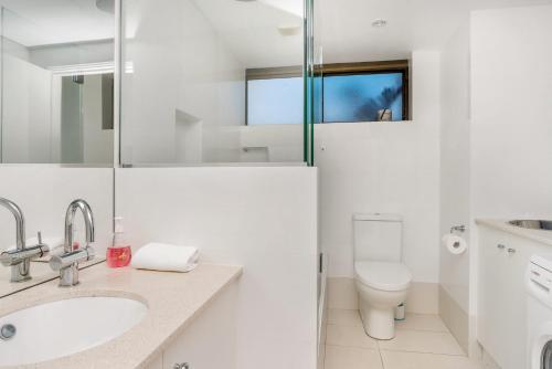 a white bathroom with a sink and a toilet at Breeze@Byron 1 Clarkes Beach in Byron Bay