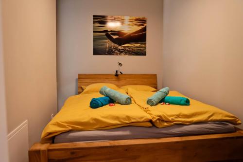 een bed met gele lakens en blauwe kussens erop bij AH Corner House in Košice
