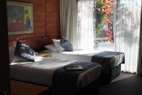 2 camas en una habitación de hotel con ventana en The Pemberton Hotel, en Pemberton
