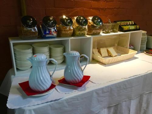 two white vases sitting on plates on a table at The Pemberton Hotel in Pemberton