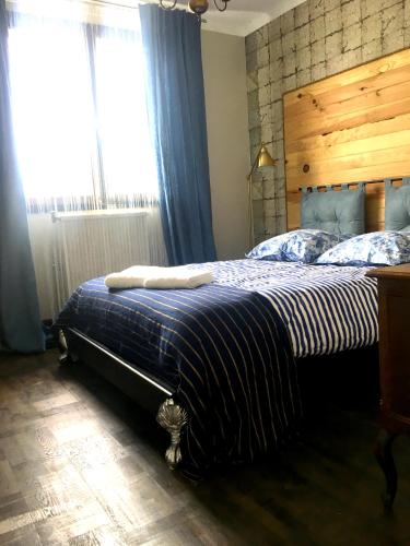 une chambre avec un lit avec une tête de lit en bois et une fenêtre dans l'établissement Villa Côte-Fleurie, à Trouville-sur-Mer