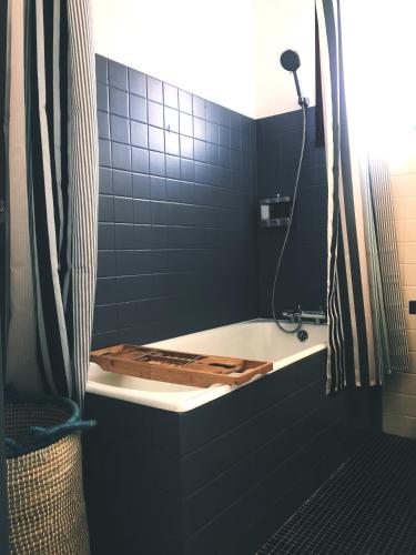 une salle de bain avec une baignoire sur laquelle est posée une planche de bois dans l'établissement Villa Côte-Fleurie, à Trouville-sur-Mer