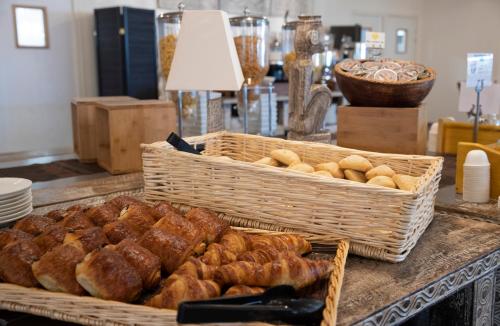 a buffet with baskets of bread and pastries on a table at Les Hauts de Beauval in Saint-Aignan
