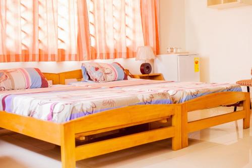 1 dormitorio con 1 cama grande de madera en una habitación en Charis Home Services, en Accra