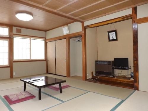 a living room filled with furniture and a tv at Togakushi- Kogen Minshuku Rindo in Nagano