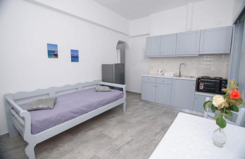 a small bedroom with a bed and a kitchen at Studios Akrogiali in Aegiali