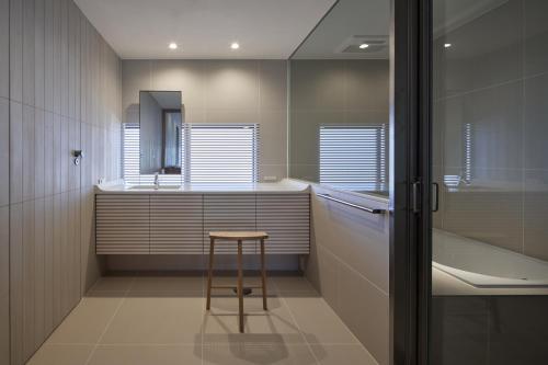 a bathroom with a stool and a sink and a tub at 滔々 御崎 二階の宿 toutou Onzaki Nikai no Yado in Kurashiki