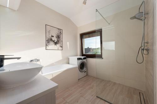 a bathroom with a sink and a washing machine at Nowe Apartamenty Puck in Puck