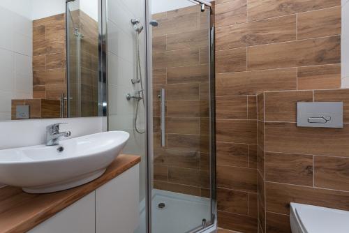 a bathroom with a sink and a shower at Nowe Apartamenty Puck in Puck