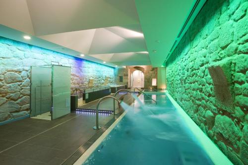 una gran piscina en un edificio con una pared de piedra en Parador de Santo Estevo, en Santo Estevo de Rivas de Sil