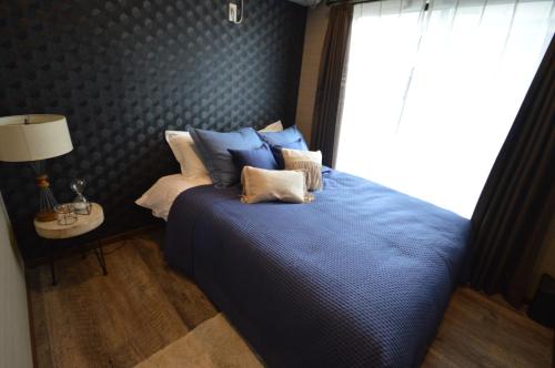 a bedroom with a blue bed with a window at enico MtFuji smile in Fujikawaguchiko
