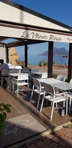 - un ensemble de tables et de chaises sur une terrasse dans l'établissement Le monte rosso, à Porto Ota