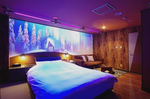 a bedroom with a large bed and purple lighting at Hotel Y's (Adult Only) in Sapporo