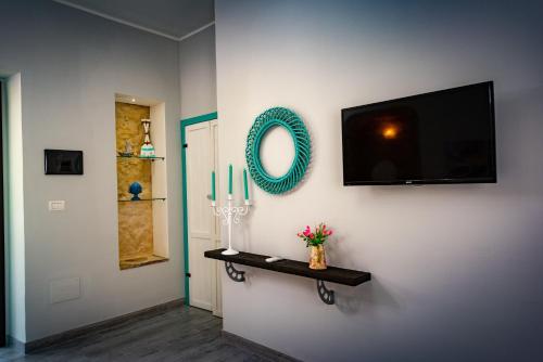 a living room with a television and a shelf with candles at Villa Primaluce in Pizzo