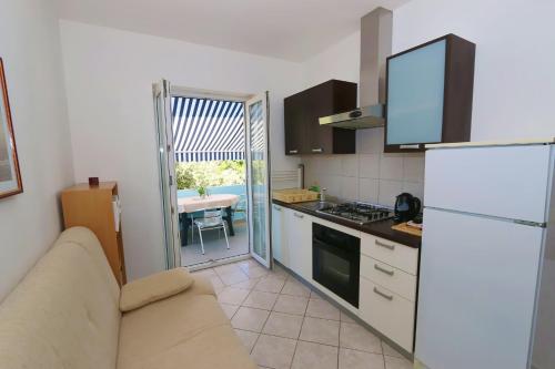 a kitchen with a couch and a refrigerator and a table at Apartments Delminium in Lun