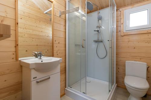 a bathroom with a shower and a sink and a toilet at Biała Wioska 2 in Ustronie Morskie