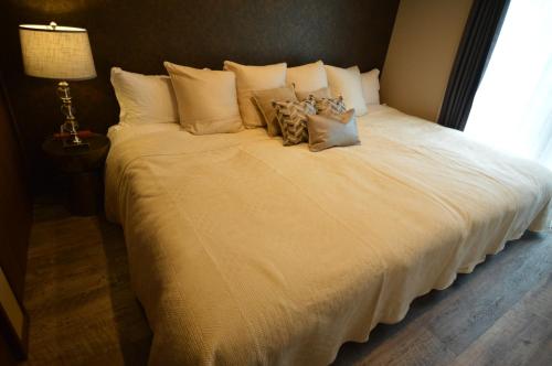 a large bed with white sheets and pillows at enico MtFuji smile in Fujikawaguchiko