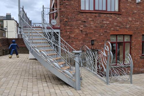 a metal staircase in front of a brick building at Silver Street Suites in Whitby