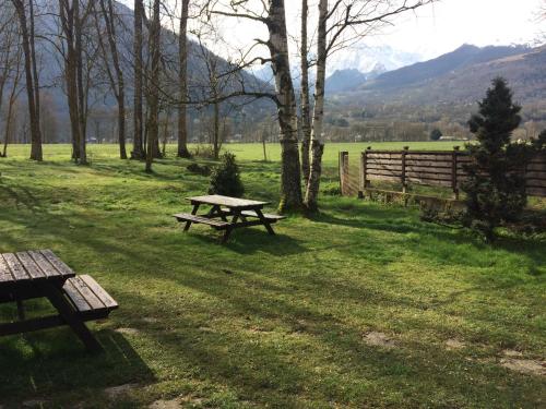 una mesa de picnic en un campo con una valla en studio panorama, en Vielle-Aure