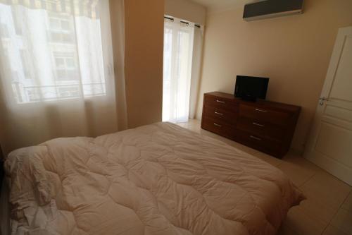 een slaapkamer met een bed, een dressoir en een raam bij Croisette Martinez 1 Bedroom 241 in Cannes