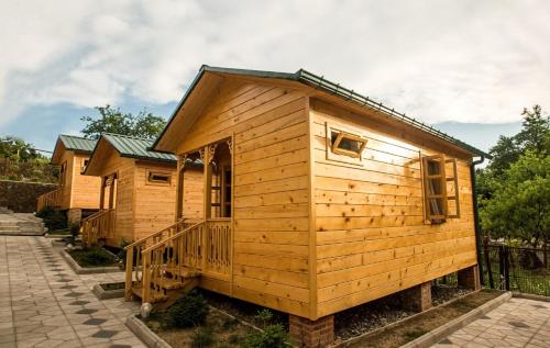 a wooden cabin with a porch and a balcony at Villa Edemi in Tskaltubo