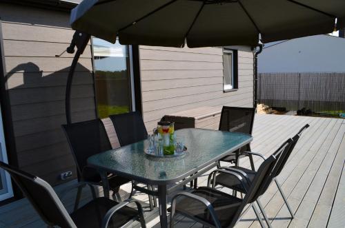 a table with chairs and an umbrella on a deck at Domeček u Prahy in Nupaky