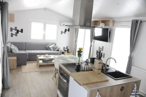 a kitchen and a living room with a couch at Domeček u Prahy in Nupaky