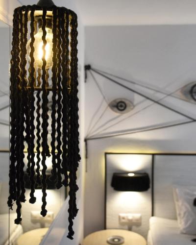 a black chandelier in a bedroom with a bed at Angelos Design Suites in Patitiri