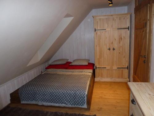 a attic room with a bed and a wooden door at Chalupa Pri vleku. in Donovaly