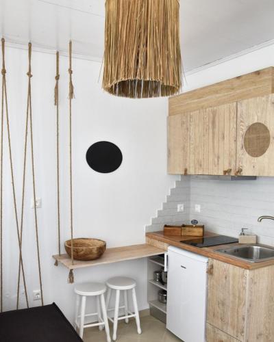 a kitchen with wooden cabinets and a sink at Angelos Design Suites in Patitiri