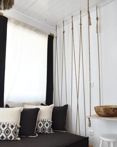 a room with a bed with black and white pillows at Angelos Design Suites in Patitiri