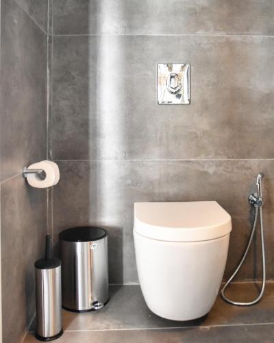 a bathroom with a toilet and a trash can at Angelos Design Suites in Patitiri