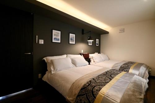 a bedroom with a large bed with white pillows at One’s Villa Sapporo House in Sapporo