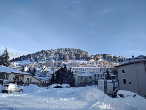 a city covered in snow with a mountain in the background at Via Roma 19 in Castel del Monte