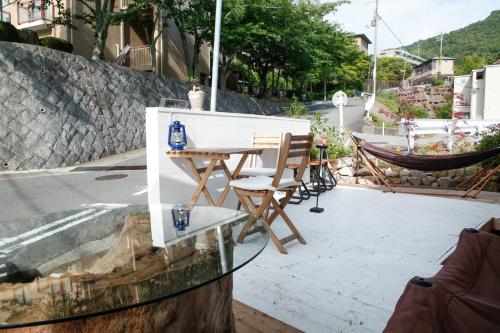 a glass table and chairs on a patio at Brücke Arima KOBE in Kobe