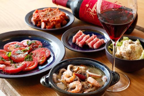 a table with plates of food and a glass of wine at Brücke Arima KOBE in Kobe
