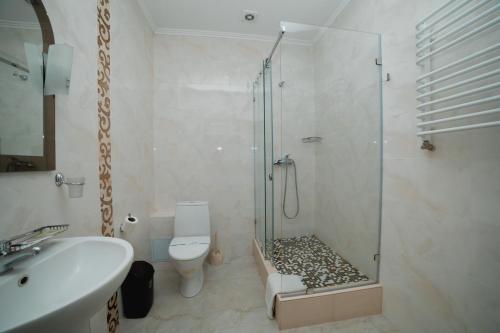 a bathroom with a shower and a toilet and a sink at Globus Hotel in Ternopilʼ