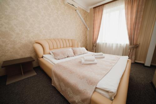 a bedroom with a large bed with two towels on it at Globus Hotel in Ternopilʼ