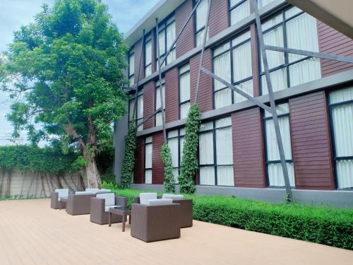 a building with chairs in front of a building at Vismaya Suvarnabhumi Hotel in Lat Krabang
