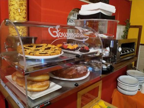 a display case with different types of pastries and desserts at Hotel Europa in Perugia